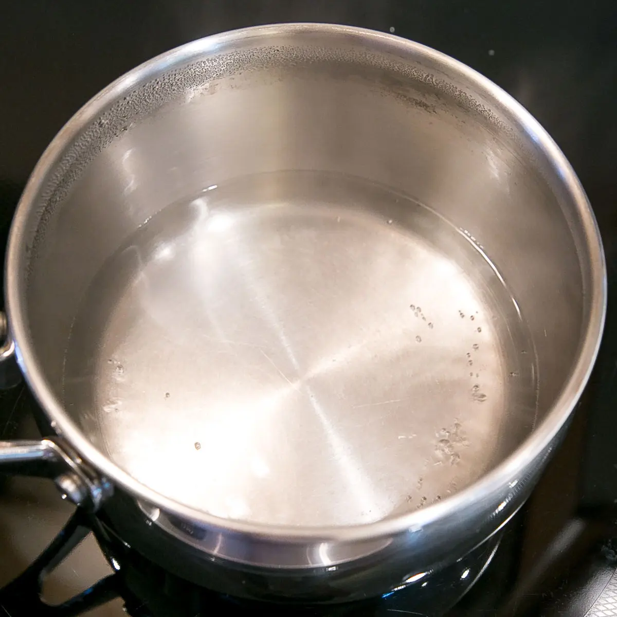 This old-fashioned 7 minute frosting recipe is light, delicious, and easy to make. A pure white frosting that's perfect for a variety of delicious desserts. | livforcake.com A pot with simmering water on the stove.