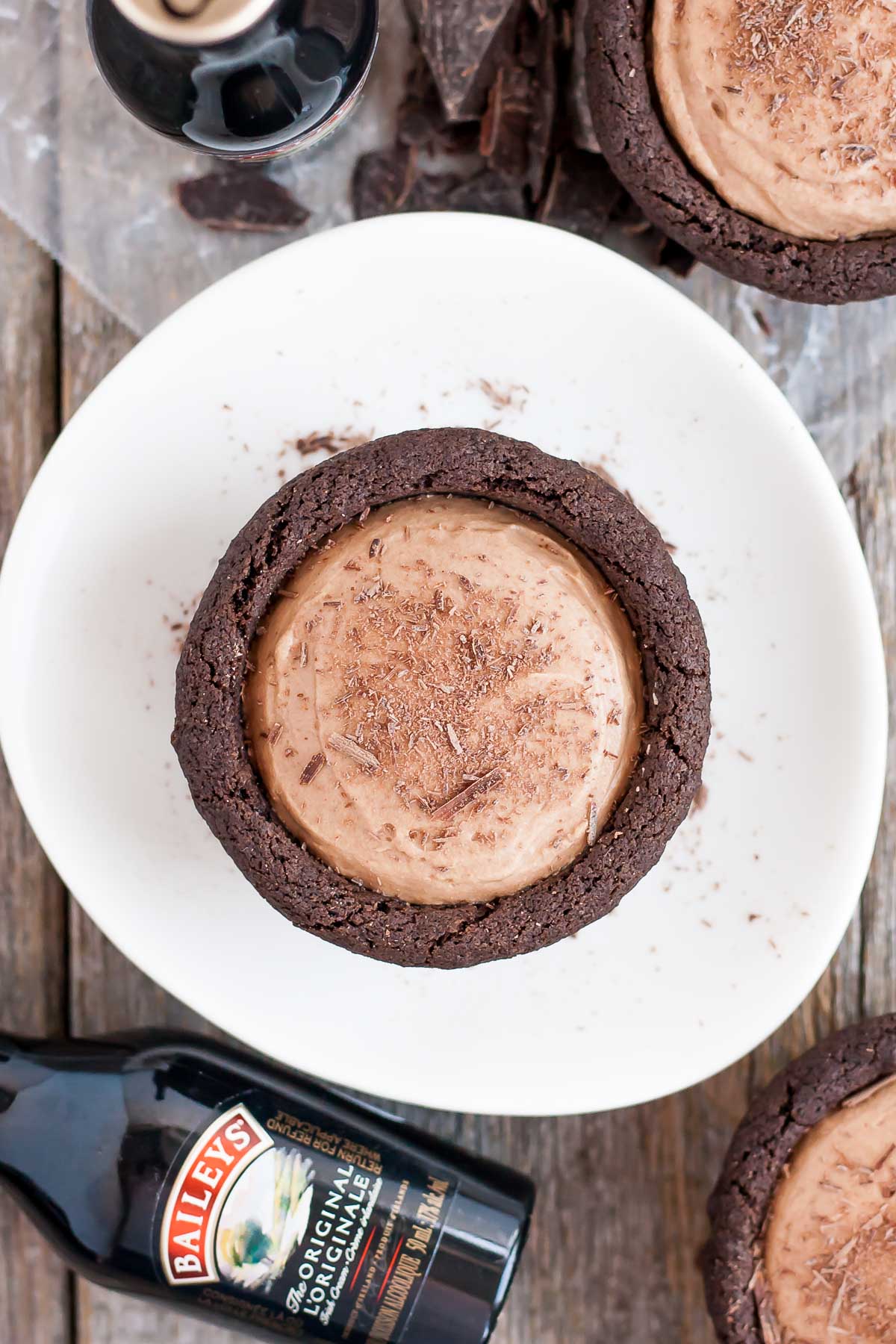 Chocolate cookie cups filled with a chocolate Baileys cheesecake. The perfect bite-sized indulgence! | livforcake.com Overhead shot of a Baileys cheesecake cookie cup.