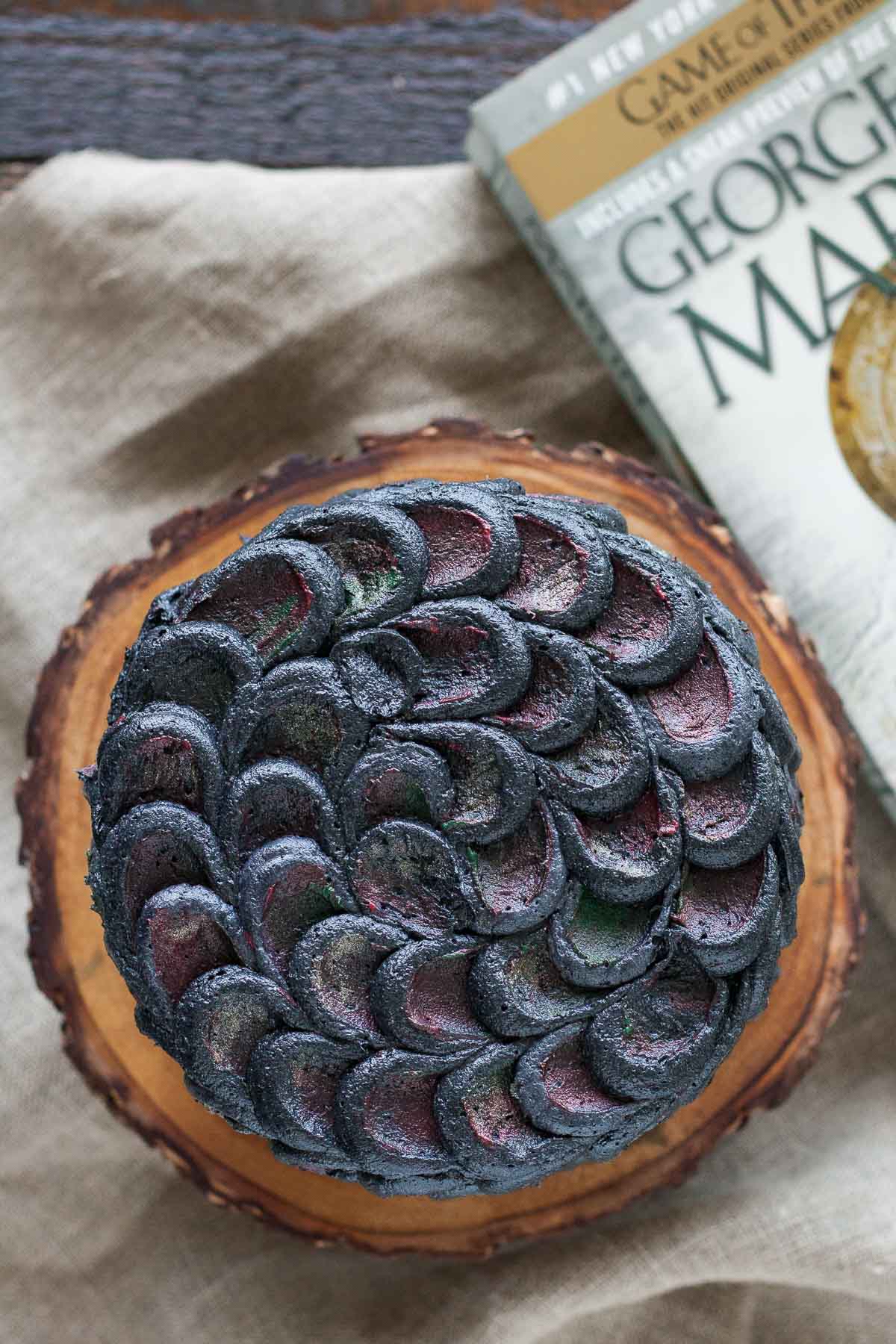 Overhead shot of the cake with a game of thrones book beside it.