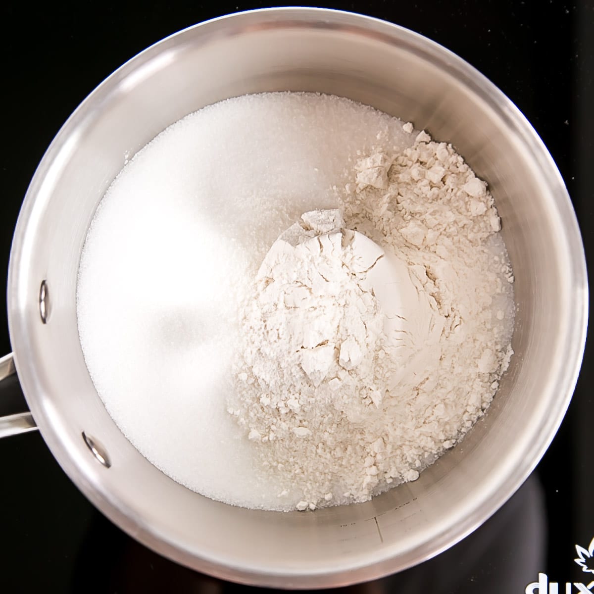 Ermine Frosting (also known as flour buttercream or heritage frosting) is an easy and delicious buttercream made with flour, sugar, milk, and butter. | livforcake.com Flour, sugar, and salt in a pot.