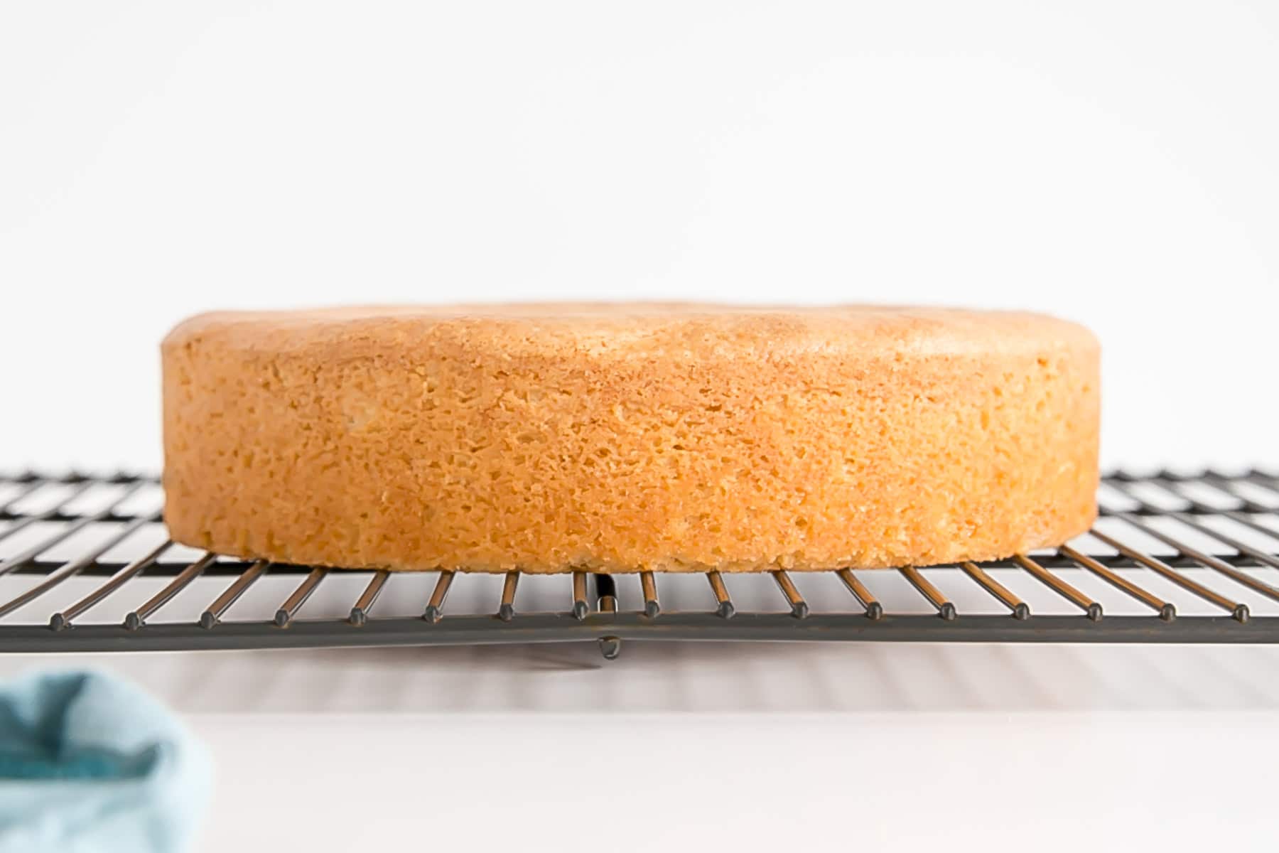 Learn how to bake flat cakes every single time! A simple tutorial on how to make sure your cakes come out nice and flat straight out of the oven. | livforcake.com Perfectly flat cake on a cooling rack.
