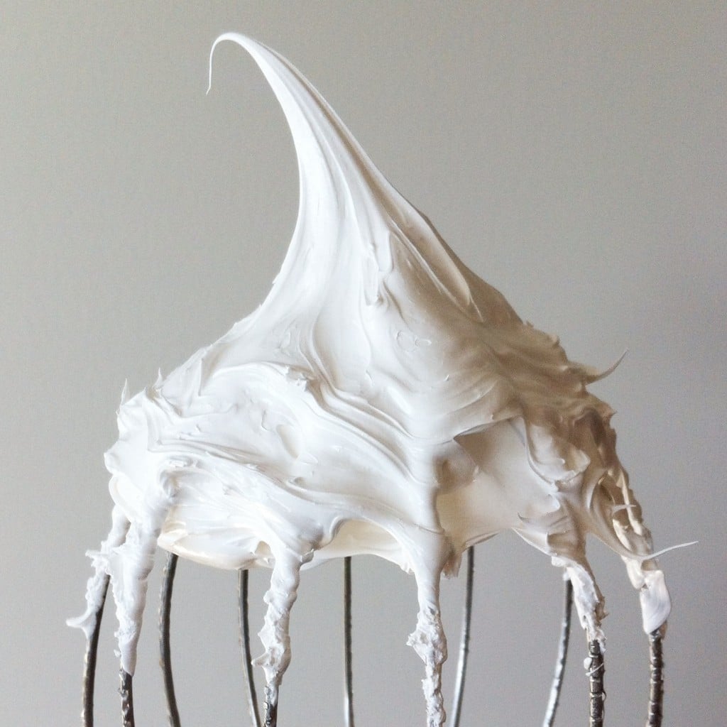 This old-fashioned 7 minute frosting recipe is light, delicious, and easy to make. A pure white frosting that's perfect for a variety of delicious desserts. | livforcake.com Close up of homemade marshmallow fluff on a stand mixer whisk.