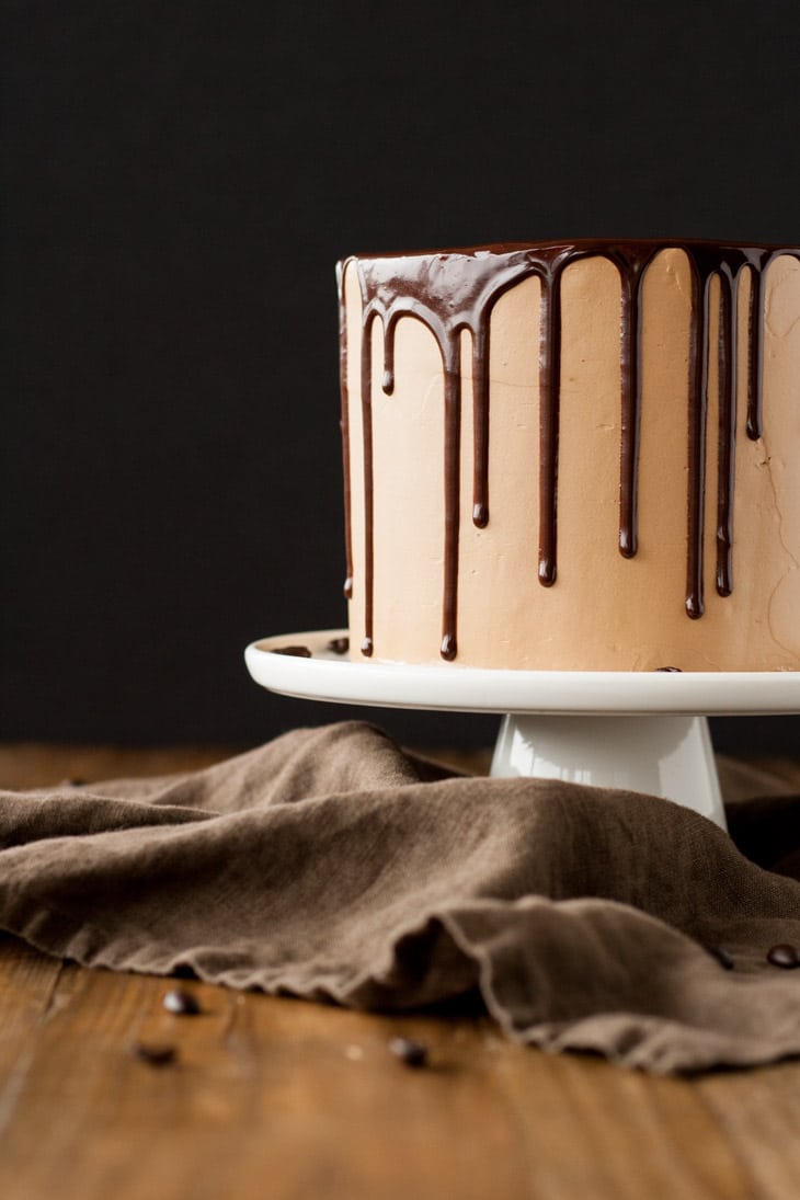 Mocha Cake! A rich dark chocolate cake with a silky mocha swiss meringue buttercream. | livforcake.com Profile shot of a mocha cake with ganache drip.