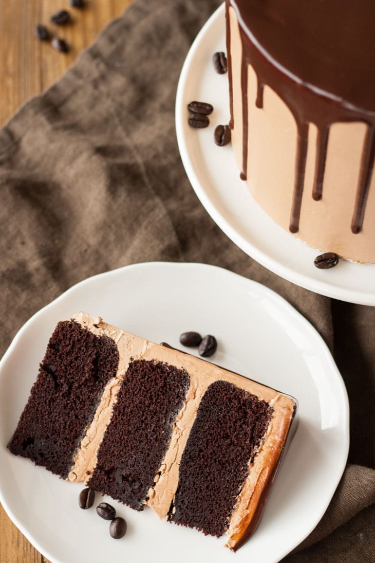 Mocha Cake! A rich dark chocolate cake with a silky mocha swiss meringue buttercream. | livforcake.com Alice of Mocha Cake on a plate.