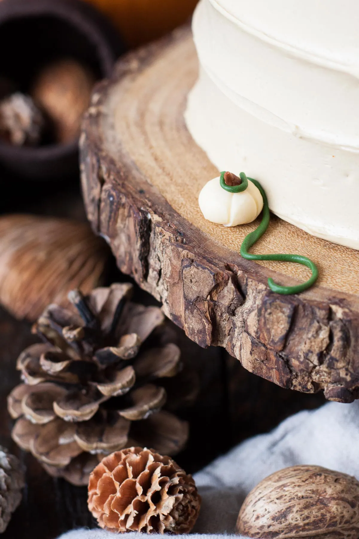 This Pumpkin Spice Latte Cake is your favorite Fall beverage in cake form! Pumpkin spice cake with an espresso buttercream. | livforcake.com Close up shot of a small fondant pumpkin with vine.