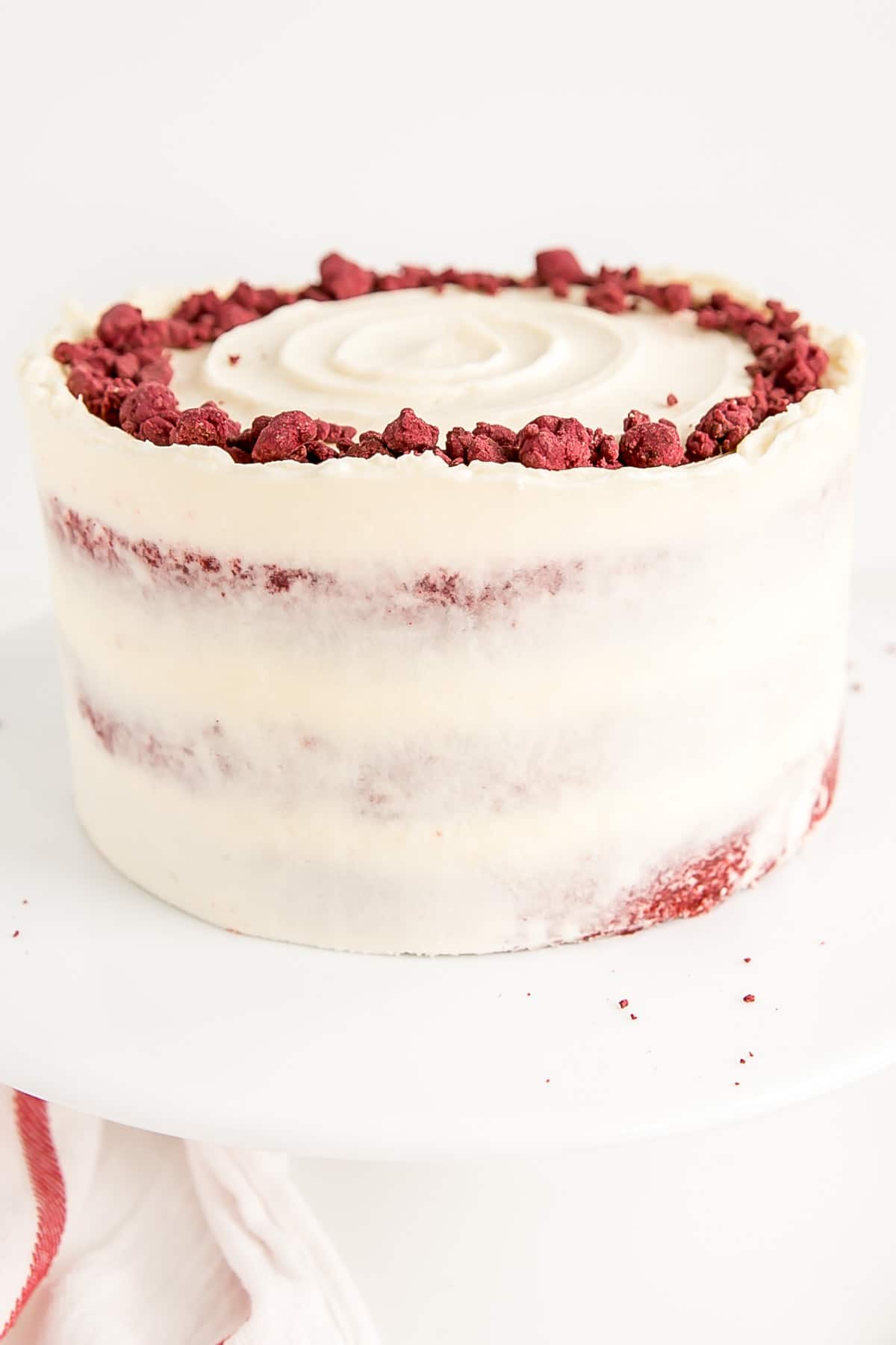 Classic Red Velvet Cake! Tender red cake layers with a hint of chocolate paired with a tangy cream cheese frosting and a red velvet crumble. | livforcake.com Close up of the crumble on top of the cake.